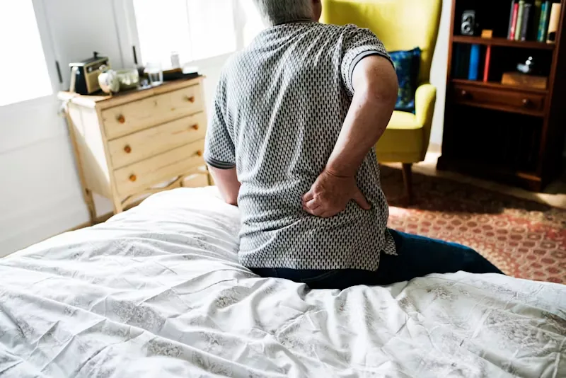 Elderly woman in pain because she suffers from a herniated disc.