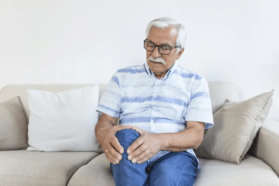 An elderly man suffers from knee cracking.