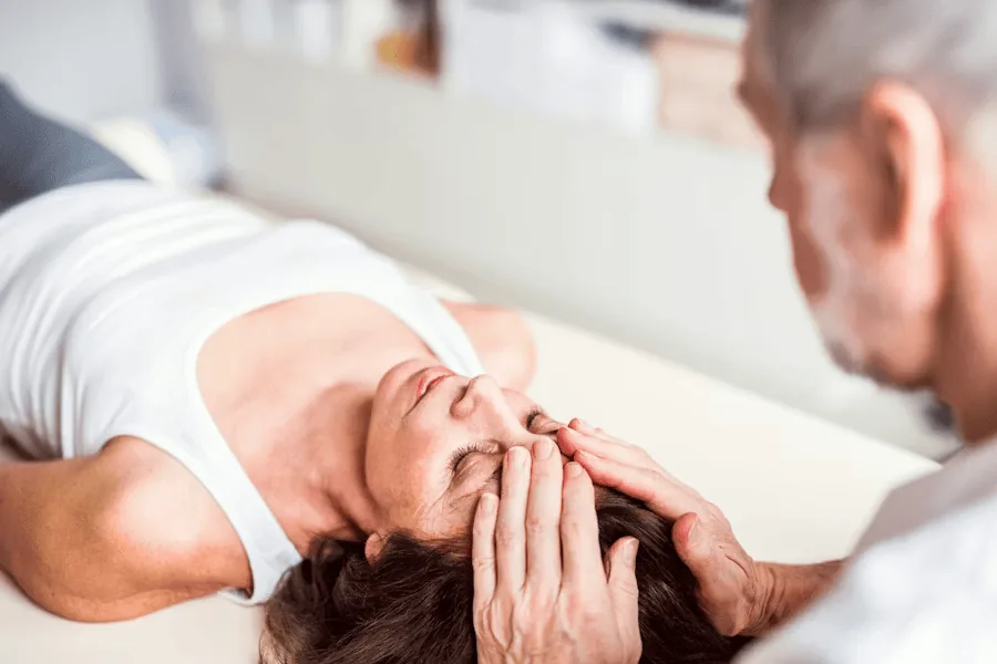 A woman receives physiotherapy to treat her tension headaches.